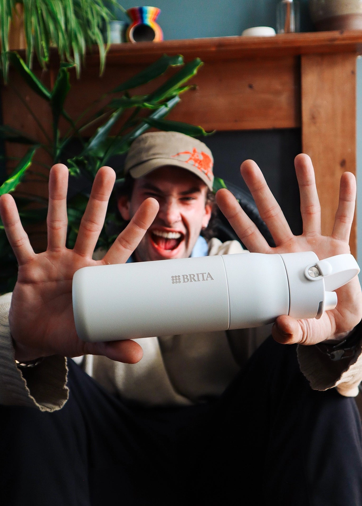Man in a cappy, proudly showing his BRITA LARQ Filter Bottle.