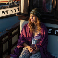 Woman sitting on a boat holding BRITA water filter bottle Model Vital, with another boat visible in the background.