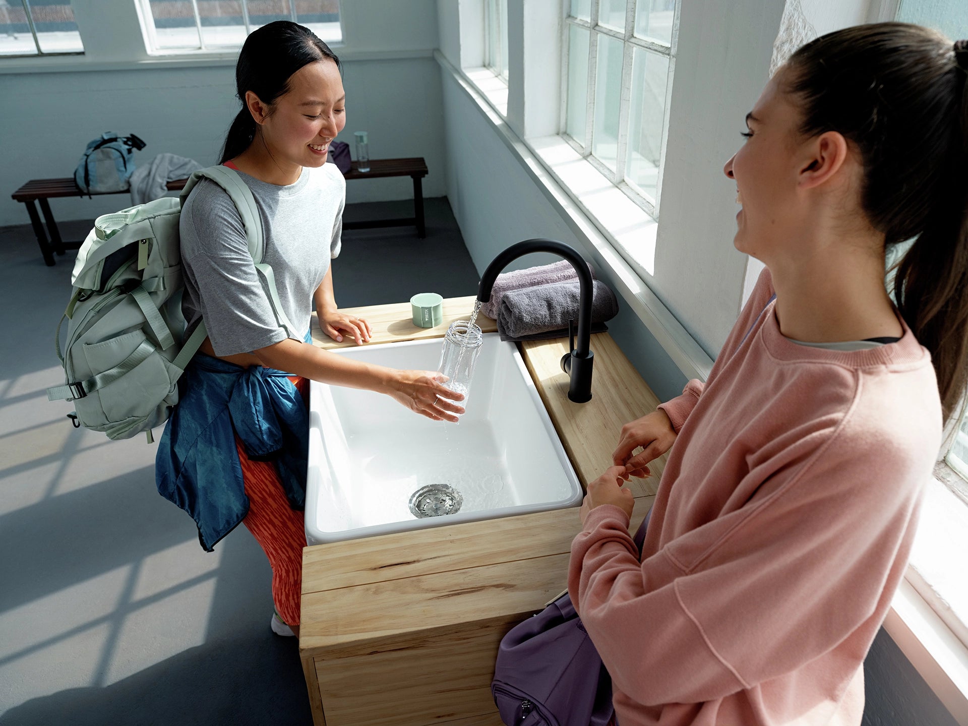 Woman filling BRITA water filter bottle Model Vital in gym