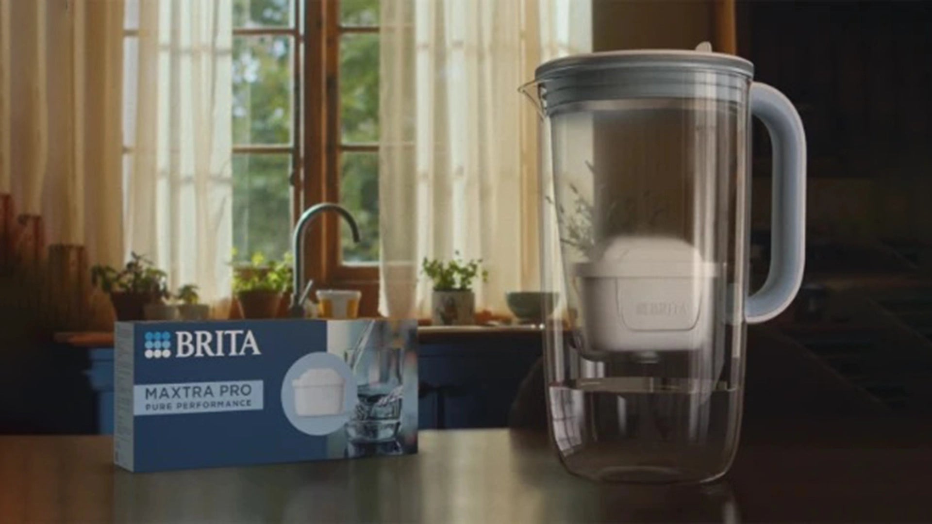 BRITA Glass Jug with MAXTRA PRO water filter packaging on a table.