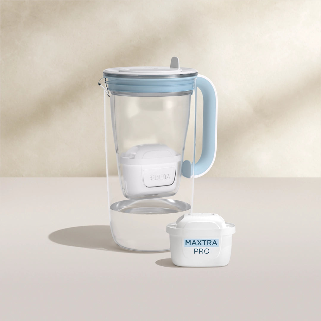 A water filter glass jug in blue on a beige background
