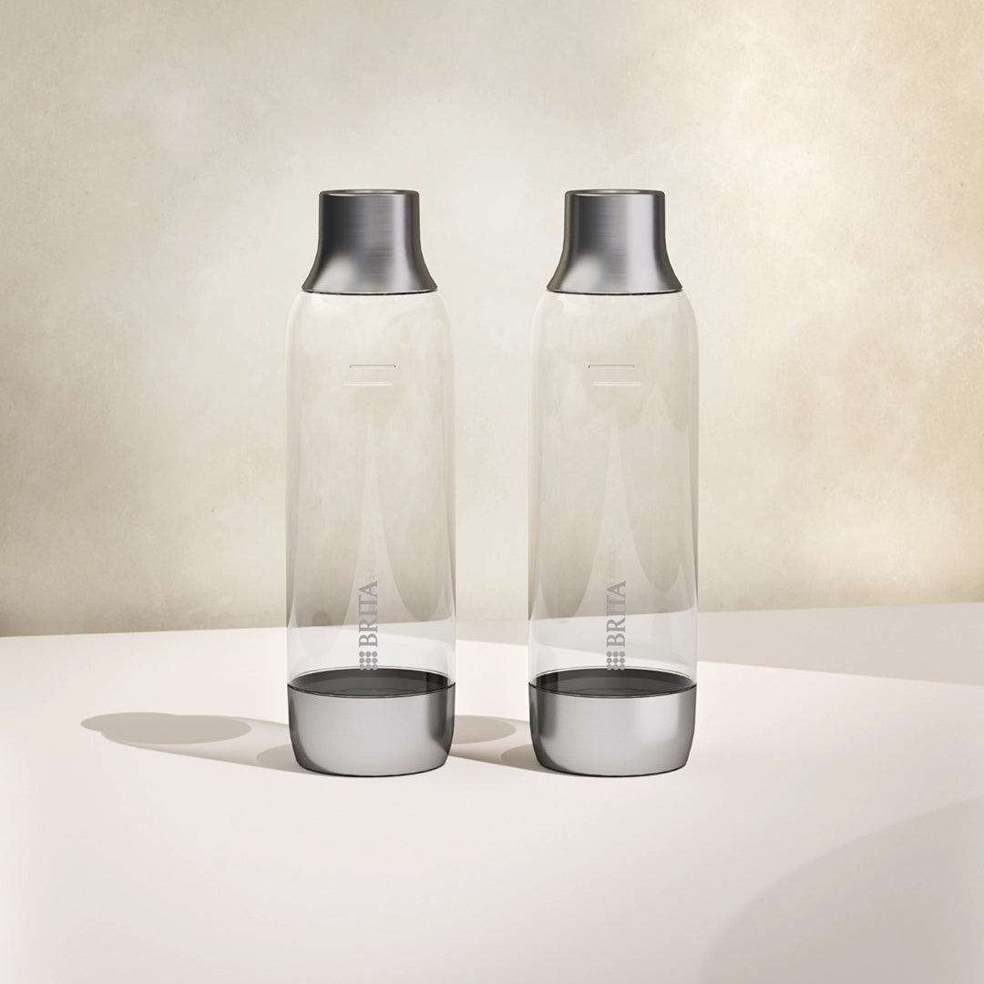 Deux BRITA sodaTRIO des bouteilles en verre alignées les unes à côté des autres sur un fond blanc