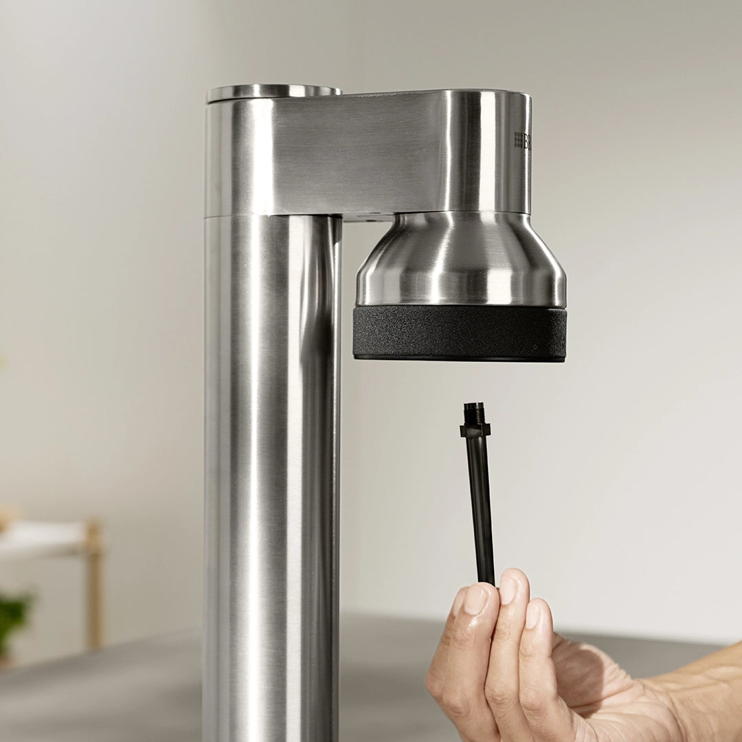 BRITA sodaTRIO Pro sparkling water maker with carbonation nozzle being inserted into the machine